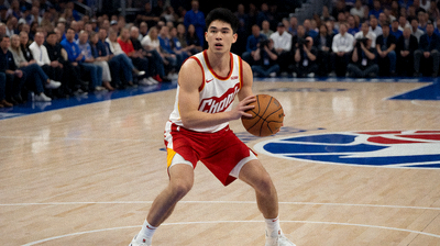 激烈职业比赛中，NBA球员在场内奋力拼搏，背景可见观众群